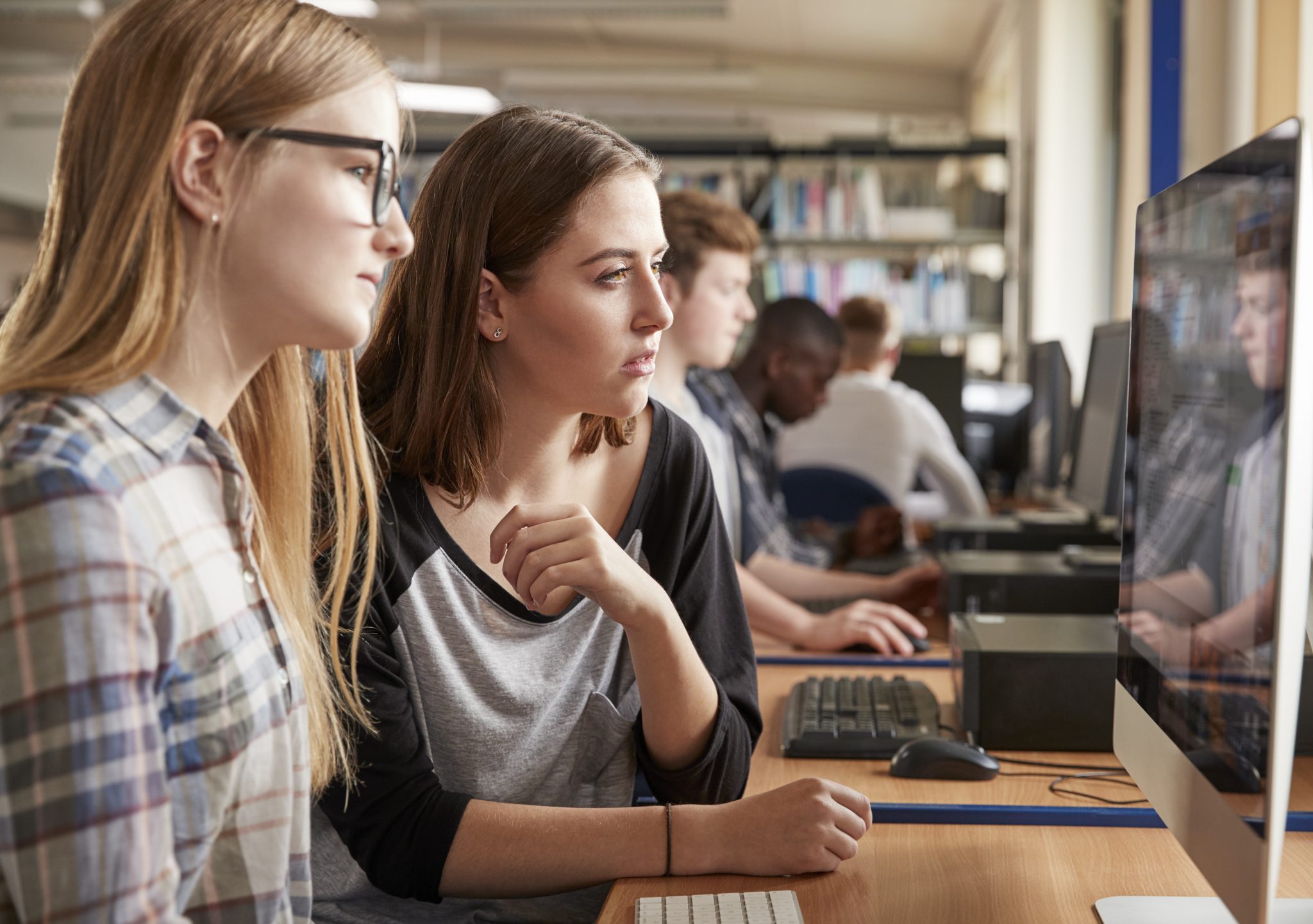 Jeunes travaillant ensemble sur ordinateur en classe.